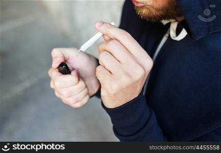 drug use, substance abuse, addiction, smoking and people concept - close up of addict hands with marijuana joint and lighter
