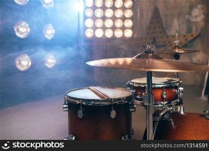 Drum kit, percussion instrument on the stage with lights, nobody. Drummer professional equipment, beat set. Drum kit, percussion instrument, beat set, nobody