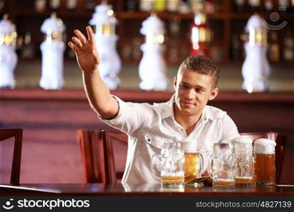 Drunk man with a beer beckons the waiter