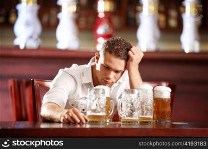 Drunk man with a beer in a pub