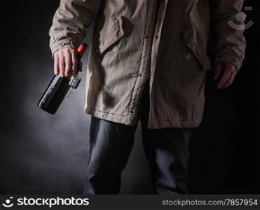Drunken driver holds a wine bottle and car keys on hand, horizon format