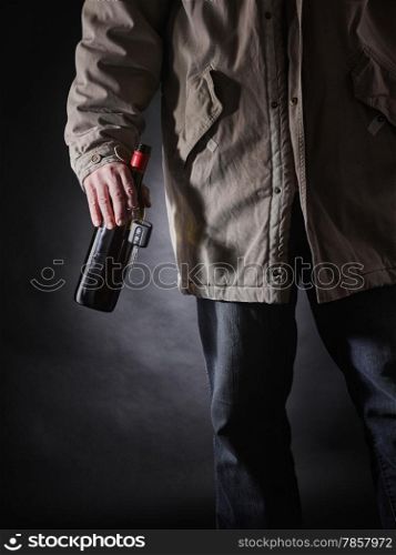 Drunken driver holds a wine bottle and car keys on hand, vertical format