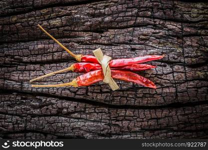 Dry chili peppers are placed on old wood.