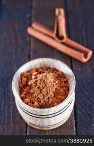 dry cinnamon in the wooden bowl and on a table