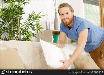 dry cleaning worker fixing a sofa indoors