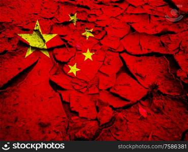 Dry cracked earth background texture with China flag background. Dry cracked earth