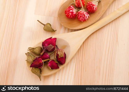 dry floral herbal tea on wood spoon over wooden table