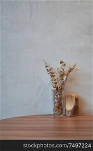 Dry flower and wood craft on wooden table for decoration with cement wall background