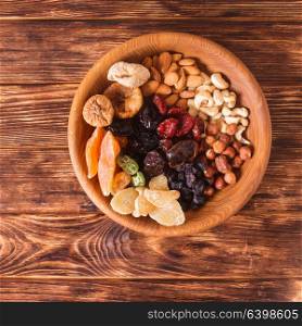 Dry fruits and nuts in bowl on wooden table. Copy space background - close up healthy sweets. Dry fruits and nuts