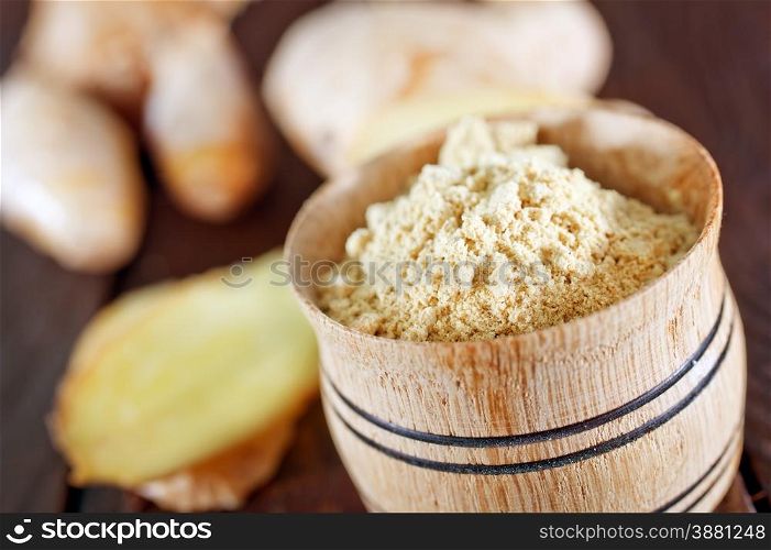 dry ginger in the wooden bowl and on a table