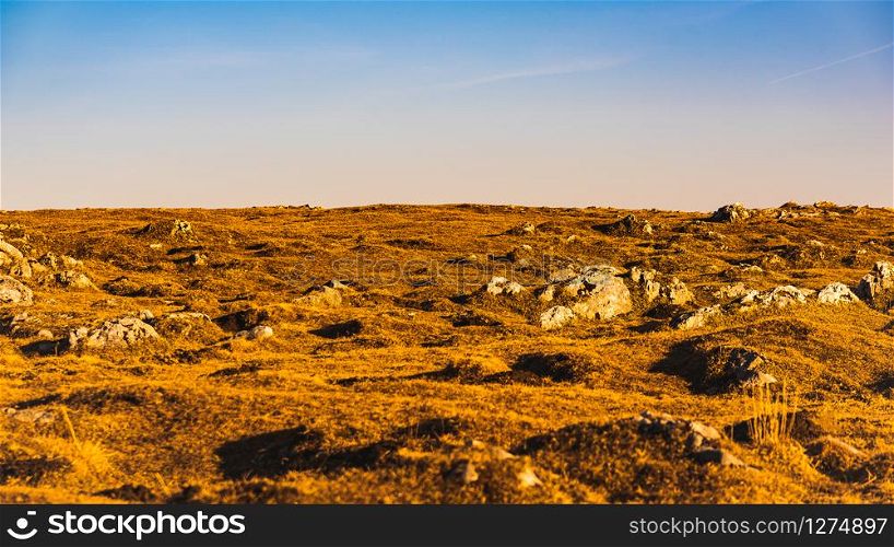 Dry grass and limestone rocks and blue sky background. Dry grass and limestone rocks and blue sky