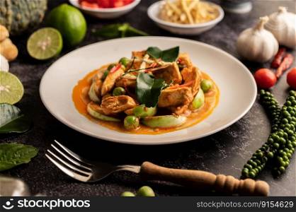 Dry green curry with chicken in white plates on black cement