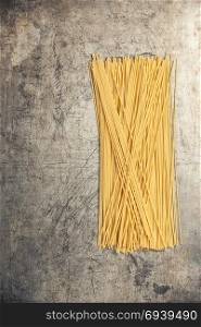Dry Italian pasta. Raw spaghetti on rustic background. Thin spaghetti. Food background concept