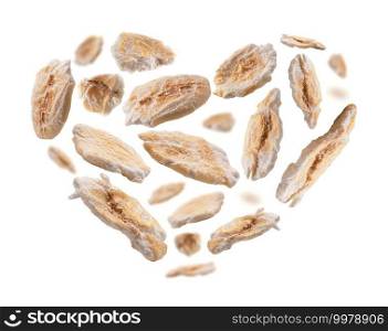 Dry oat flakes in the shape of a heart on a white background.. Dry oat flakes in the shape of a heart on a white background