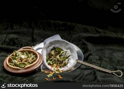 Dry pandan leaf, indian marsh fleabane plant leaves with Safflower dried (Saffron substitute) at dark background. Thai herbal plant and healthy drinks concept. Selective focus.
