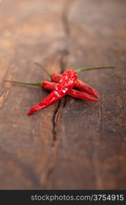 dry red chili peppers over old wood table