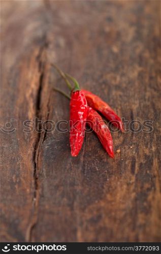dry red chili peppers over old wood table