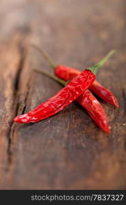 dry red chili peppers over old wood table