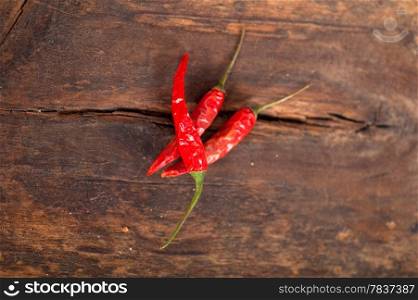 dry red chili peppers over old wood table