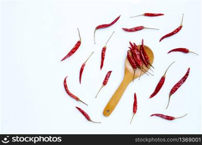 Dry red hot chili peppers on wooden spoon on white background. Copy space