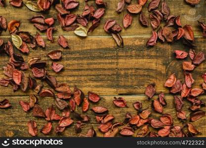 Dry red petals for wallpaper on a wooden background