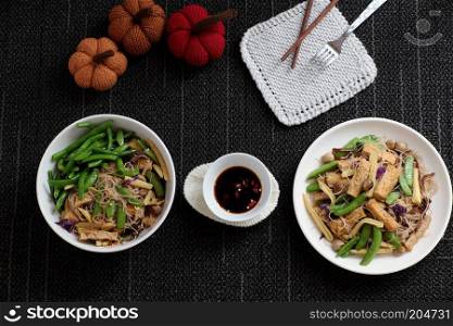 Dry rice vermicelli fried with vegetables from top view, a Vietnamese vegetarian dish for vegans, a dish can make quick for breakfast at home from noodle, vegetable, mushroom, tofu