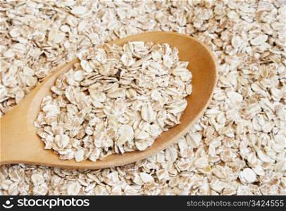 Dry rolled oats seed in wooden spoon