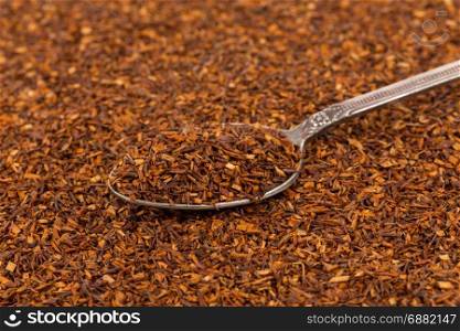 Dry rooibos healthy traditional organic tea close up in spoon