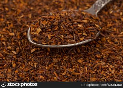 Dry rooibos healthy traditional organic tea close up in spoon
