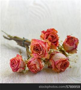 Dry roses isolated old wooden table
