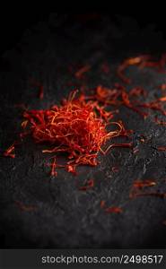 Dry saffron petals spices heap on table