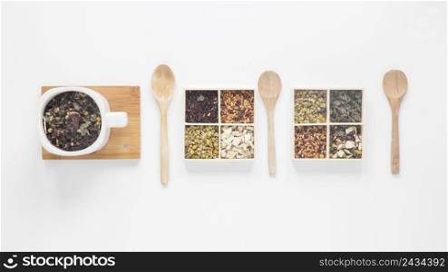 dry tea leaves herbs wooden spoon arranged row white background