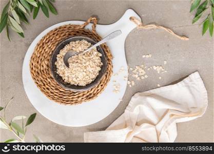 Dry thick oat flakes in a ceramic bowl in kitchen counterto. Concept of healthy eating, dieting, dietary fiber