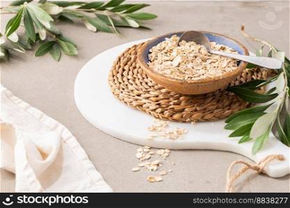 Dry thick oat flakes in a ceramic bowl in kitchen counterto. Concept of healthy eating, dieting, dietary fiber