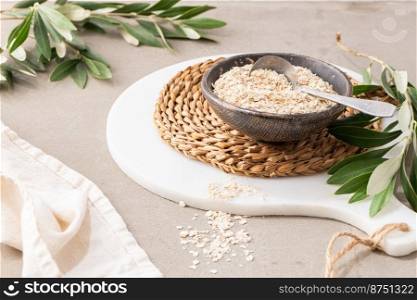 Dry thin oat flakes in a ceramic bowl in kitchen counterto. Concept of healthy eating, dieting, dietary fiber
