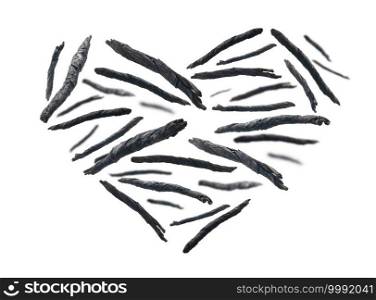 Dry twisted leaves of Kuding tea in the shape of a heart on a white background.. Dry twisted leaves of Kuding tea in the shape of a heart on a white background