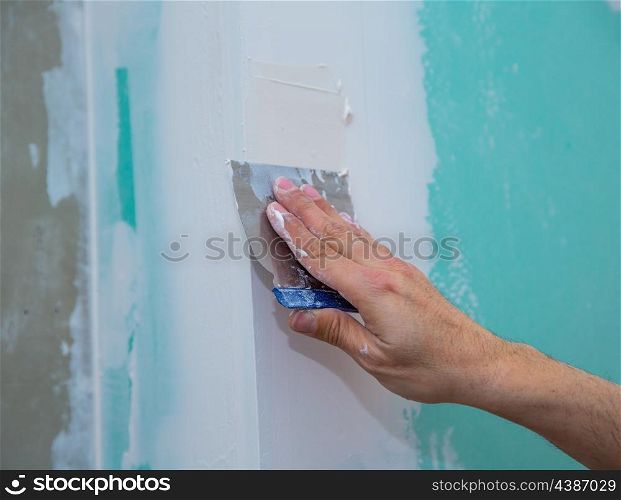 drywall hydrophobic plasterboard in green plastering seam with trowel