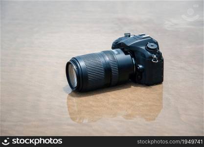 DSLR camera with telephoto lens on a beach it wet from water sea wave when travel and test using in the extreme environment demo waterproof by photographer. DSLR camera on beach wet from water sea wave