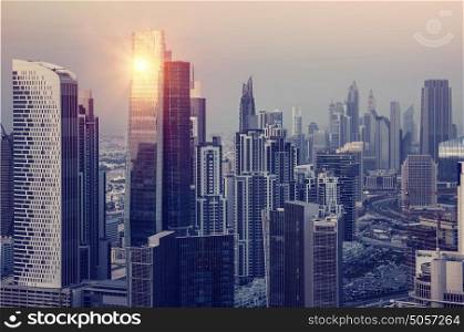 Dubai downtown in the evening, luxury modern buildings in bright yellow sunset light, futuristic cityscape, expensive life in UAE