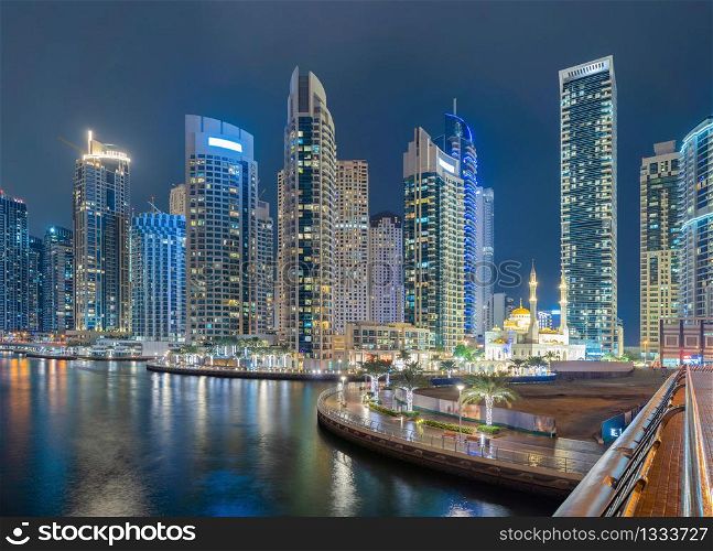 Dubai Marina and lake or river, Downtown skyline, United Arab Emirates or UAE. Financial district and business area in smart urban city. Skyscraper and high-rise buildings at night. Architecture.