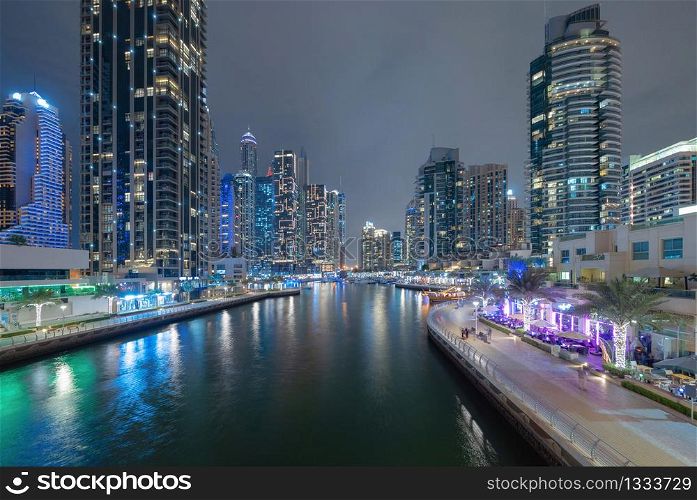 Dubai Marina and lake or river, Downtown skyline, United Arab Emirates or UAE. Financial district and business area in smart urban city. Skyscraper and high-rise buildings at night. Architecture.