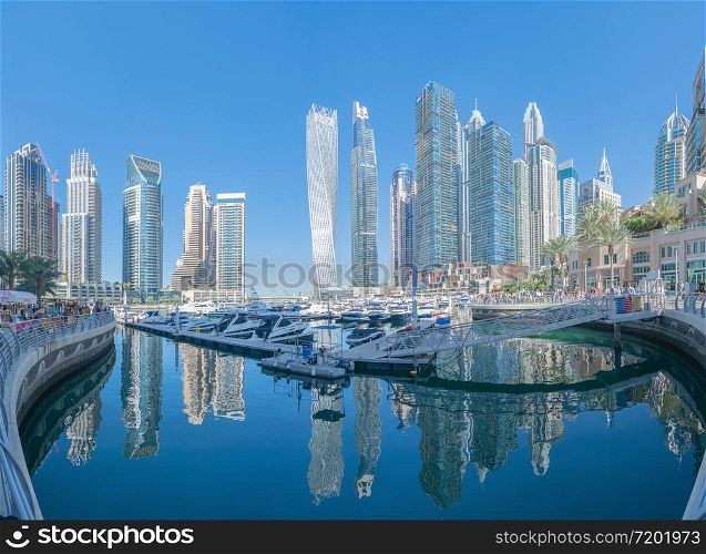 Dubai Marina and lake or river, Downtown skyline, United Arab Emirates or UAE. Financial district and business area in smart urban city. Skyscraper and high-rise buildings with blue sky. Architecture.