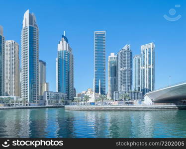 Dubai Marina and lake or river, Downtown skyline, United Arab Emirates or UAE. Financial district and business area in smart urban city. Skyscraper and high-rise buildings with blue sky. Architecture.