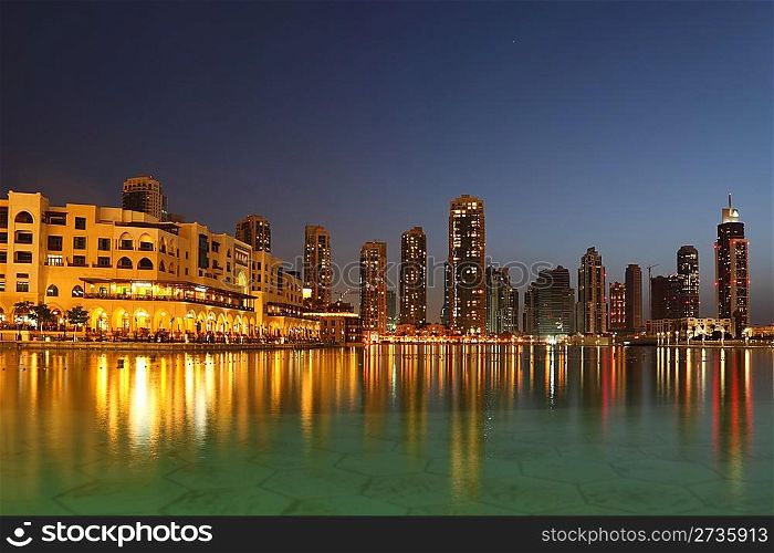 Dubai skyscrapers and other buildings at night time, view from water