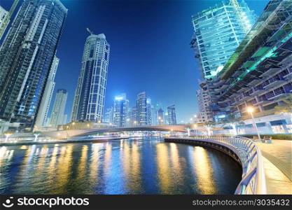DUBAI, UAE - DECEMBER 5, 2016: Dubai Marina buildings and night city lights. Dubai attracts 30 million tourists annually.. DUBAI, UAE - DECEMBER 5, 2016: Dubai Marina buildings and night