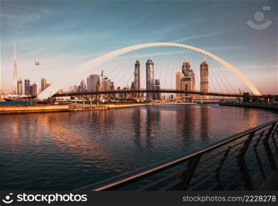 DUBAI, UAE - FEBRUARY 2018  Colorful sunset over Dubai Downtown skyscrapers and the newly built Tolerance bridge as viewed from the Dubai water canal.