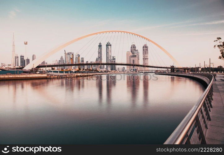 DUBAI, UAE - FEBRUARY 2018  Colorful sunset over Dubai Downtown skyscrapers and the newly built Tolerance bridge as viewed from the Dubai water canal.