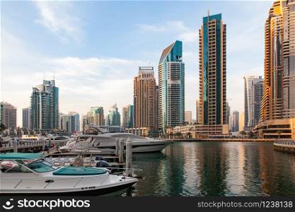 DUBAI, UAE - FEBRUARY 2018: View of modern skyscrapers shining in sunrise lights in Dubai Marina in Dubai, UAE