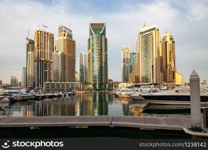 DUBAI, UAE - FEBRUARY 2018: View of modern skyscrapers shining in sunrise lights in Dubai Marina in Dubai, UAE