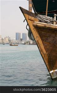 Dubai, UAE, old wooden dhow docked on Dubai Creek, Rolex Towers of Deira in distance